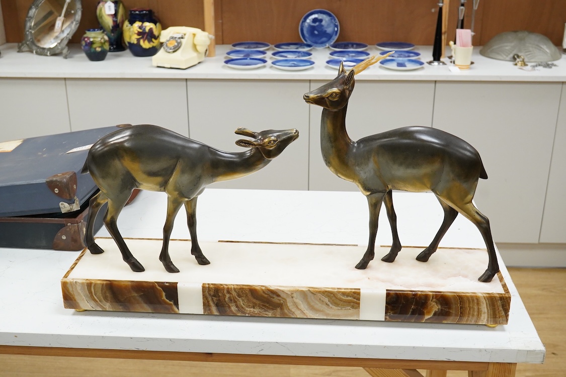 An Art Deco spelter and marble stag and deer group, 70cm wide
